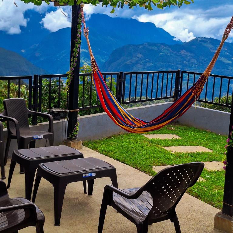 a hammock on a patio with a view of mountains at Casa la Colina in Macanal