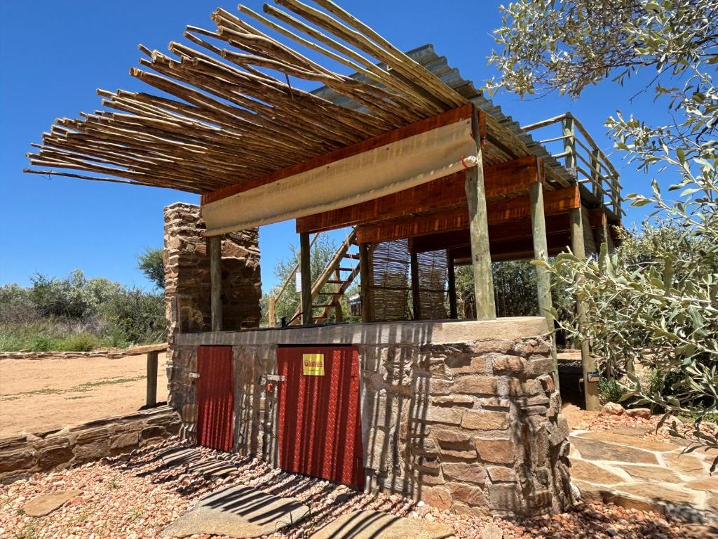 a building with a red door and a roof at BellaTiny Campsite with camping cabin for 4 in Windhoek
