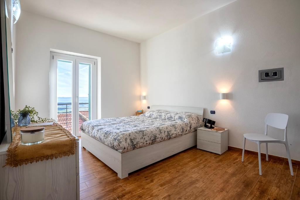 a bedroom with a bed and a table and a chair at Casa Rinascita con Piscina Privata in Nulvi