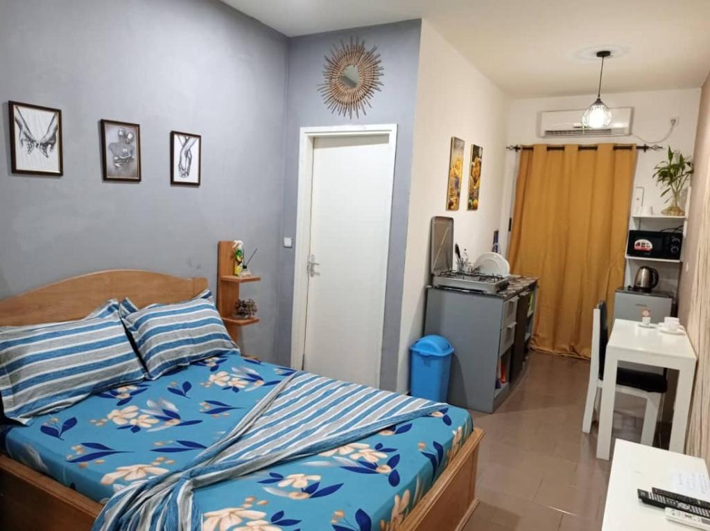ein Schlafzimmer mit einem Bett mit blauer Bettdecke in der Unterkunft La Résidence Vanessa in Pointe-Noire