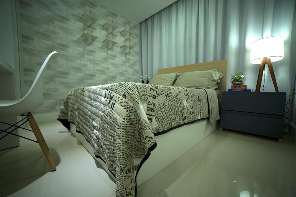 a bedroom with a bed with a black and white comforter at Flat Farol da Barra 2 in Salvador