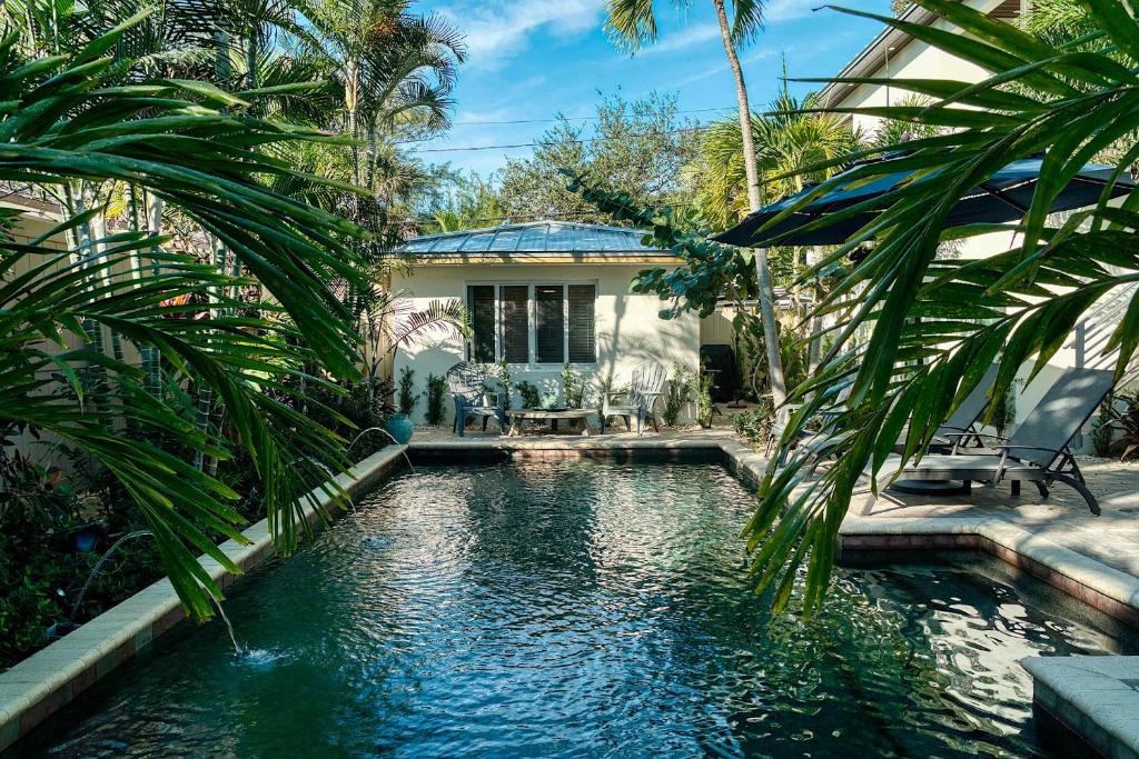 a house with a swimming pool in front of a house at Charming Studio w Pool One Mile to Beach Pets Welcome in Lake Worth