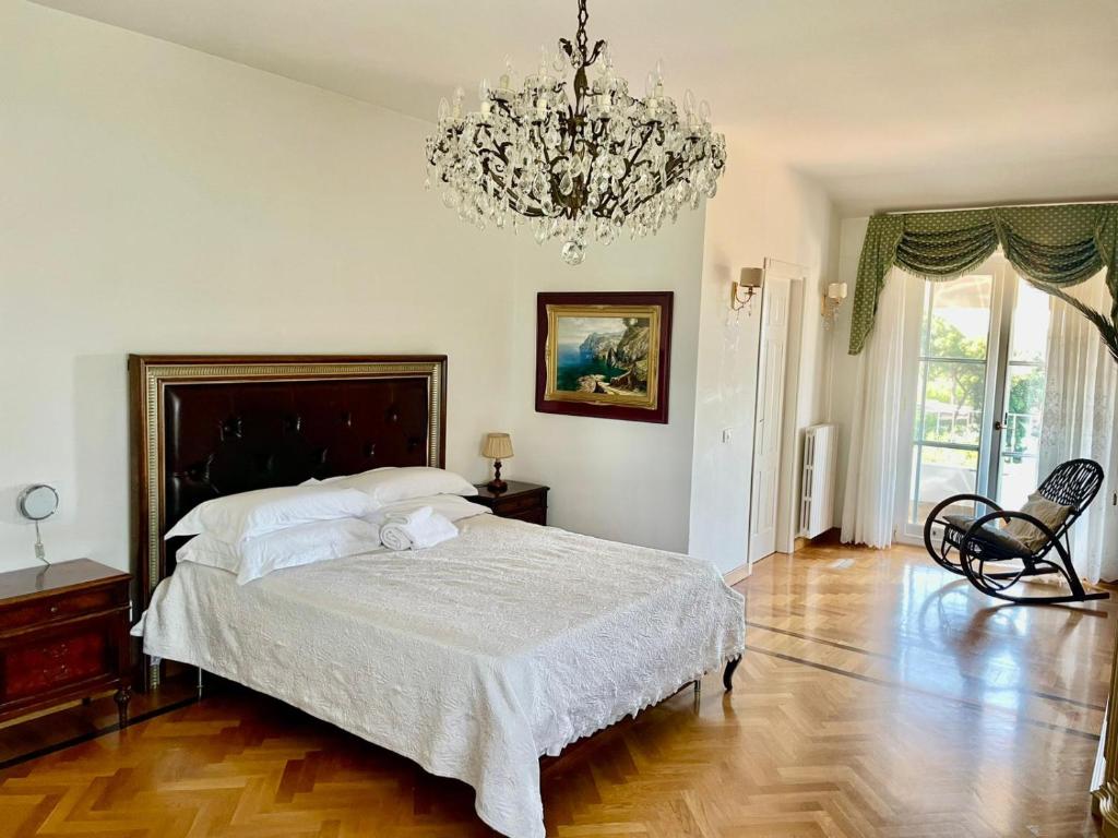 a bedroom with a large bed and a chandelier at Villa Rosa in Torre del Greco