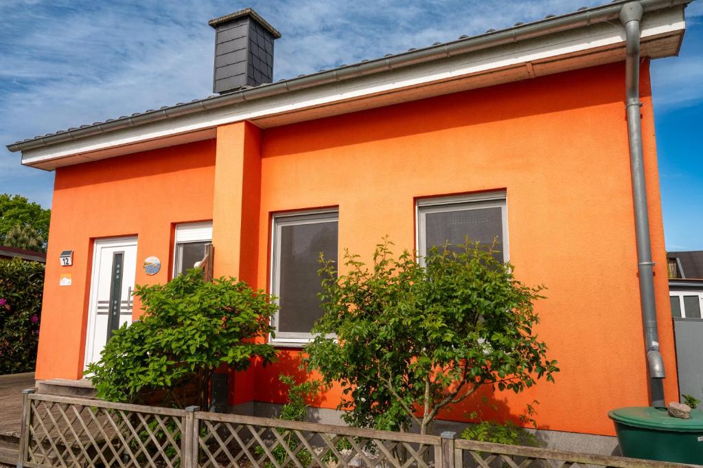an orange house with a fence in front of it at Mö 71-Inselblick in Mönkebude