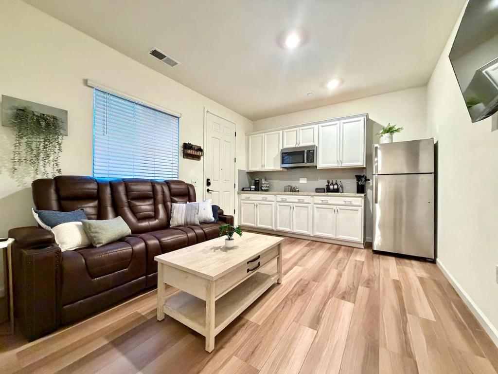 a living room with a brown couch and a refrigerator at Attached Guest House in Woodland