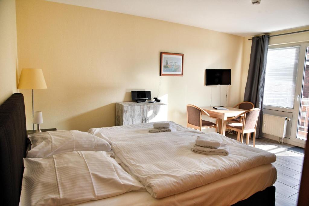 a hotel room with a large bed and a table at Lagunenstadt am Haff - Fewo 196 Gaffel in Ueckermünde