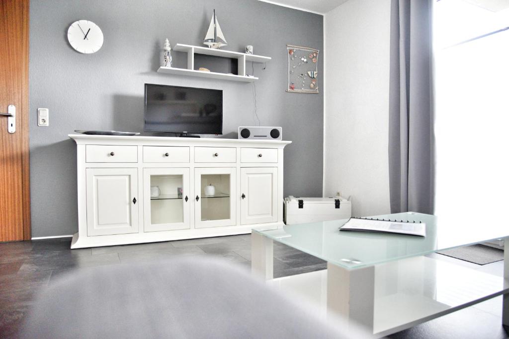 a living room with a white cabinet with a tv at Lagunenstadt am Haff - Fewo 34 Palstek in Ueckermünde