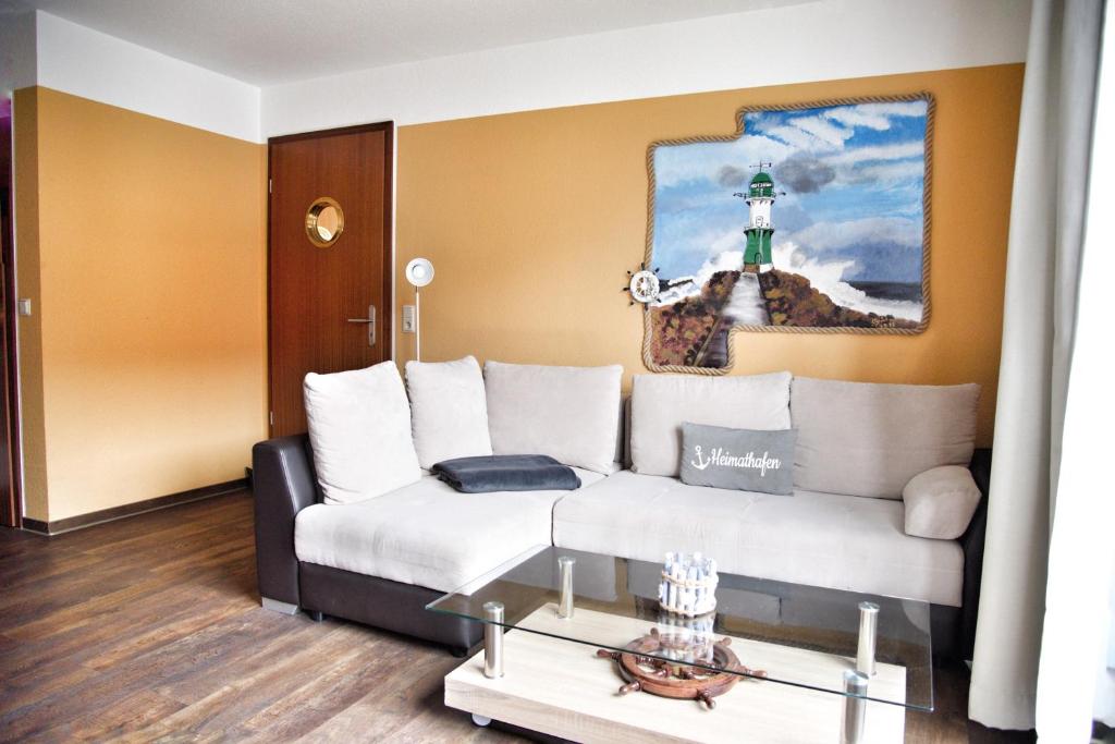 a living room with a white couch and a lighthouse at Lagunenstadt am Haff - 133 Hol über! in Ueckermünde