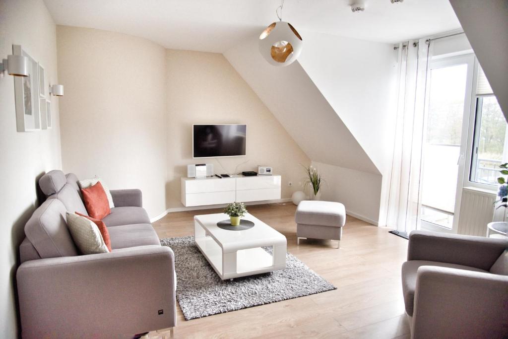 a living room with a couch and a tv at Lagunenstadt am Haff - Fewo 161 Arielle in Ueckermünde