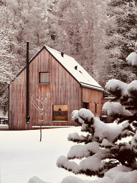 a wooden barn in the snow with trees at Jiná báseň in Pustá Rybná