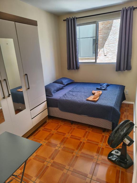 a bedroom with a bed and a desk and a chair at Quarto em Apartamento na Trindade in Florianópolis