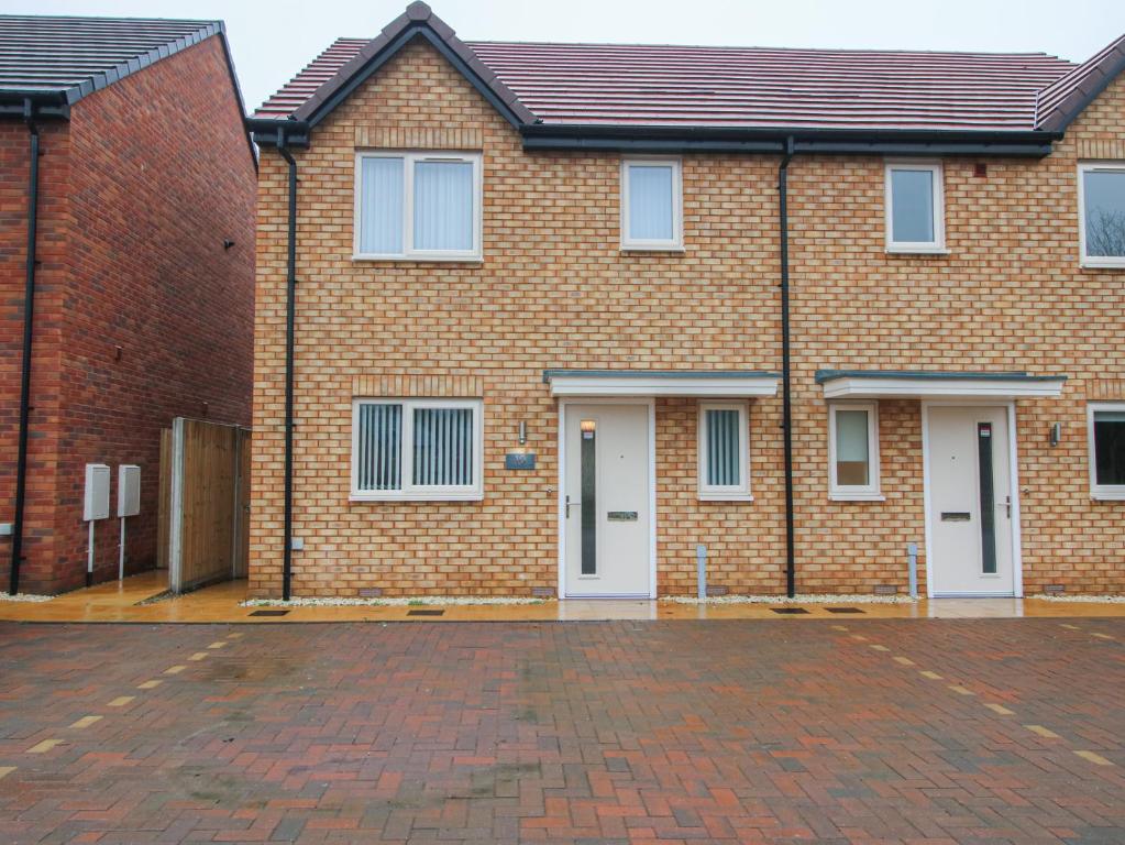 a brick house with white doors and a brick driveway at 10 The Colliery in Telford