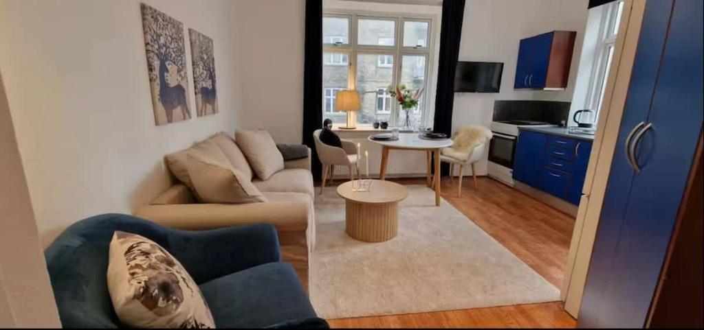 a living room with a couch and a table at Central 1BR Studio - Walk Everywhere in Aarhus in Aarhus