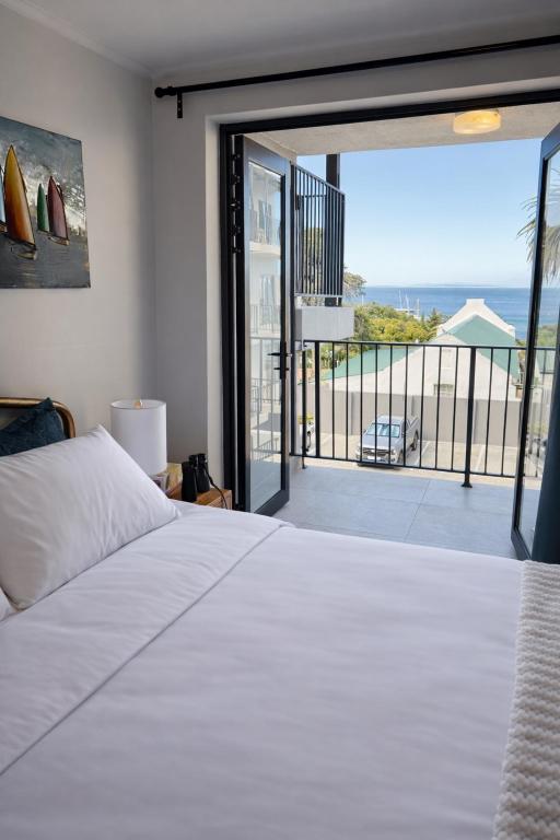 a bedroom with a bed and a view of the ocean at Marina Views Simon's Town, Near Long Beach in Simonʼs Town