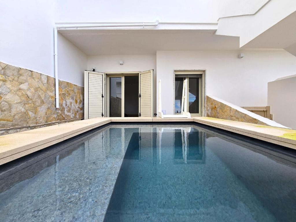 an indoor swimming pool with blue water in a house at Villetta Tina Private Pool - Torre Pali in Torre Pali