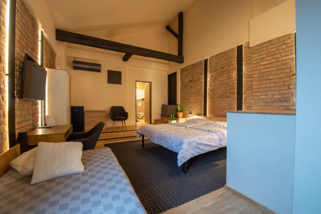 a bedroom with a bed and a brick wall at Apartmány Caffe & Grill in Roudnice nad Labem
