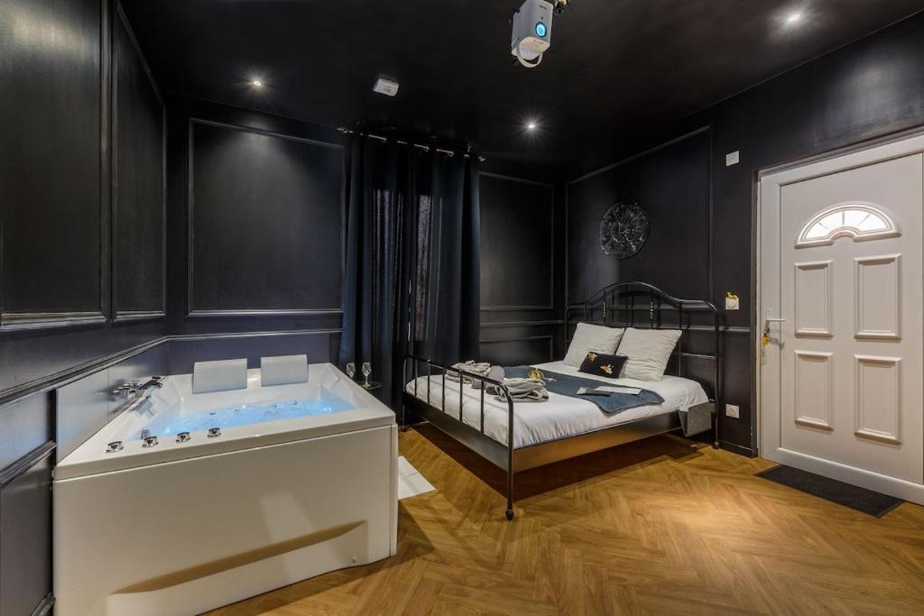 a bedroom with a bed and a tub in it at Le Spa Nocturne in Le Petit-Quevilly