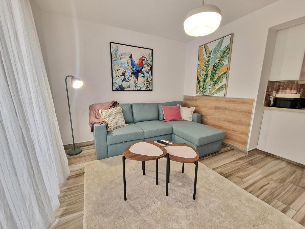a living room with a blue couch and two tables at Triumph 1 - A in Paralimni