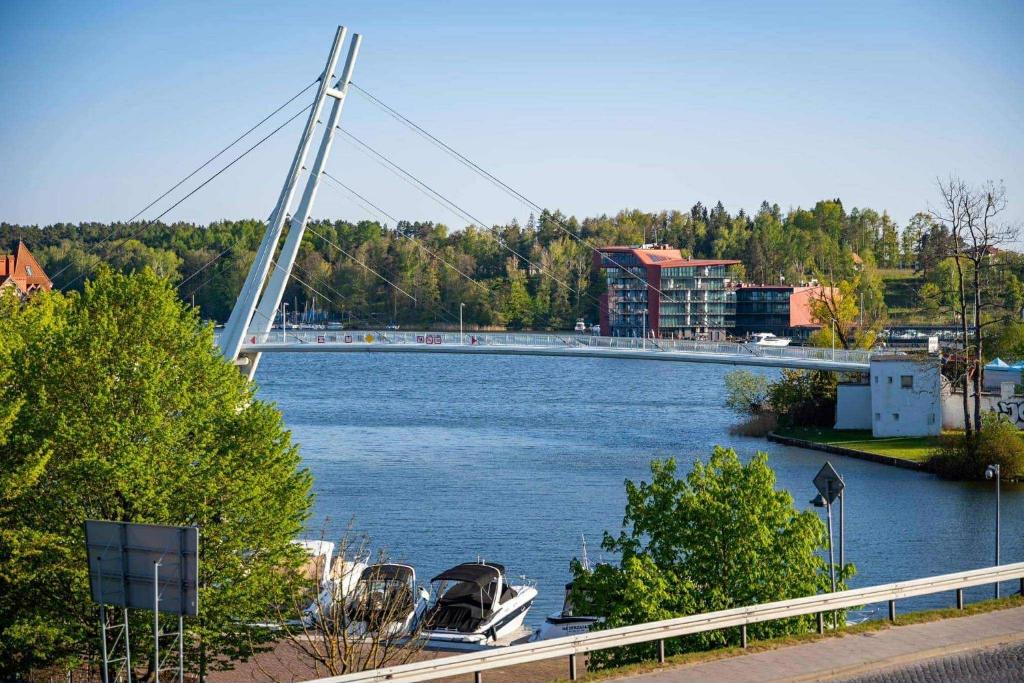 a bridge over a river with boats in the water at LAKE VIEW House in Mikołajki
