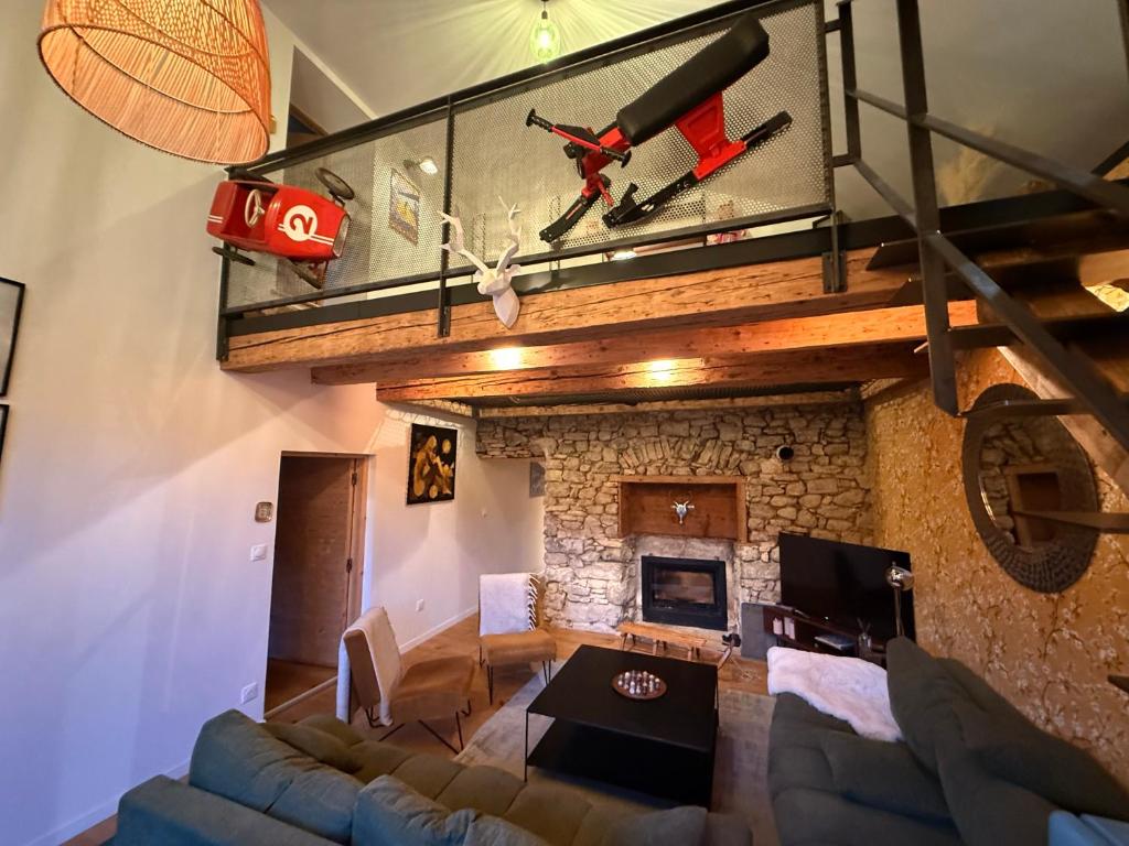 a living room with a couch and a stone fireplace at La Grange d'Annalys in Granges-Narboz