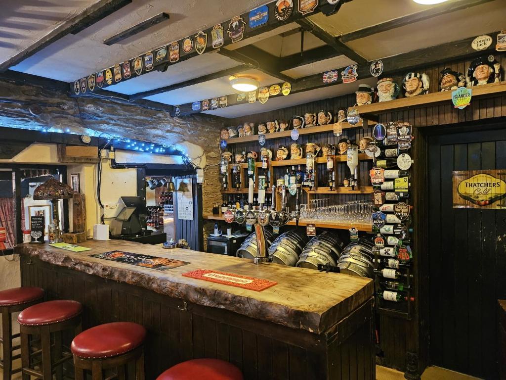 a bar in a pub with stools and bottles of alcohol at The Rockford Inn in Lynton