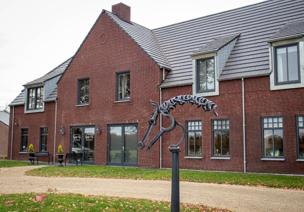 a large brick building with a statue in front of it at Eighty One Horse Boulevard in Valkenswaard