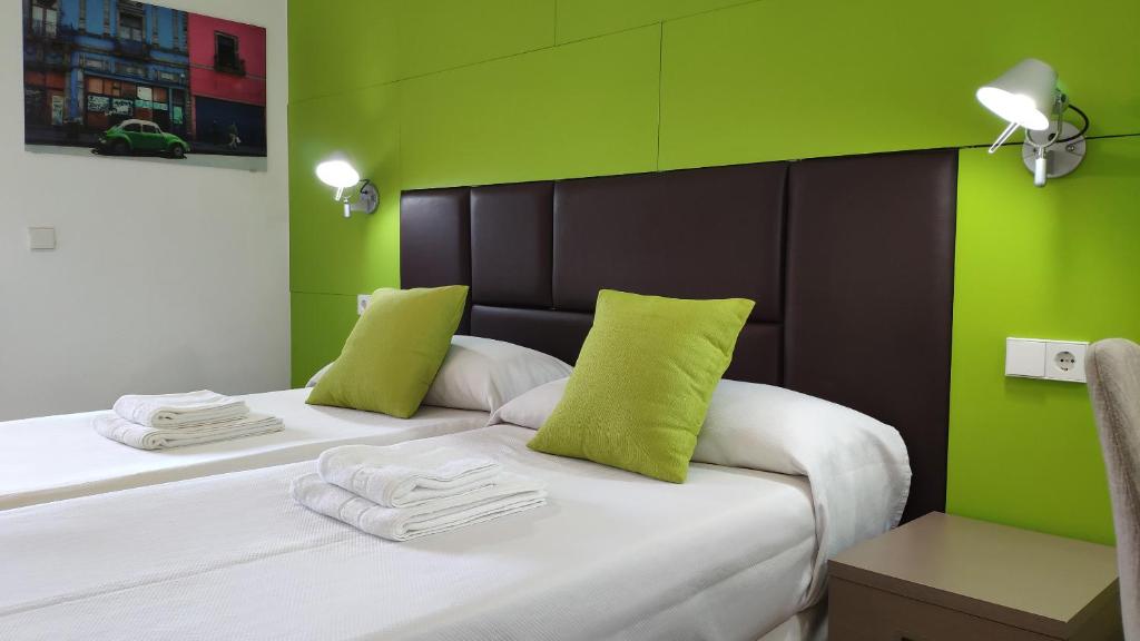 a bedroom with two beds with lime green walls at Huéspedes Sa Font in Ibiza Town