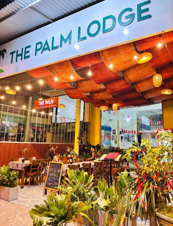 a restaurant with people sitting at tables in front of it at Palm Lodge in Bố Trạch