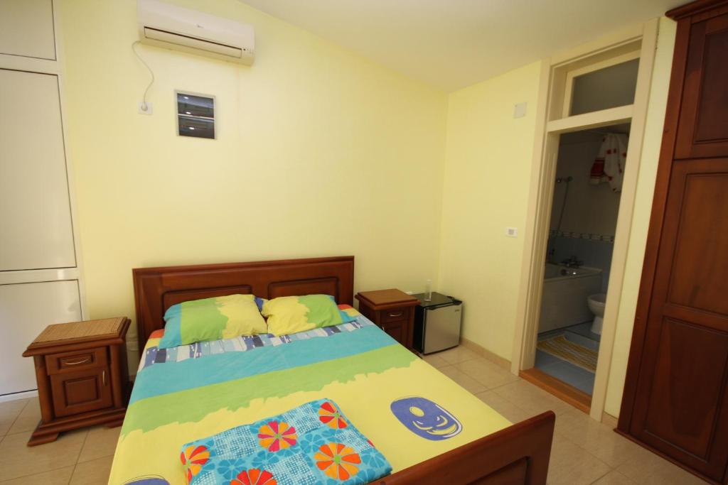 a bedroom with a bed and a bathroom with a tub at Apartments Nensy in Bar