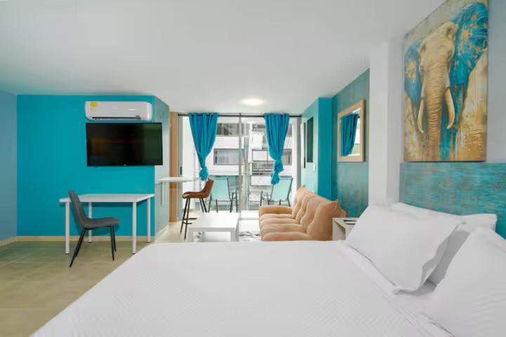 a bedroom with a white bed and a blue wall at Leb'Den Executive Suites in Cali