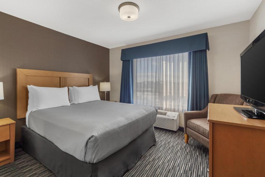 a hotel room with a bed and a television at Best Western Grande Prairie in Grande Prairie