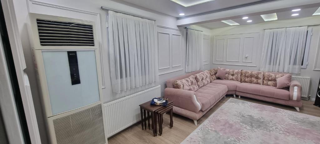 a living room with two pink couches and a table at Özer hızarcıoglu in Talipler