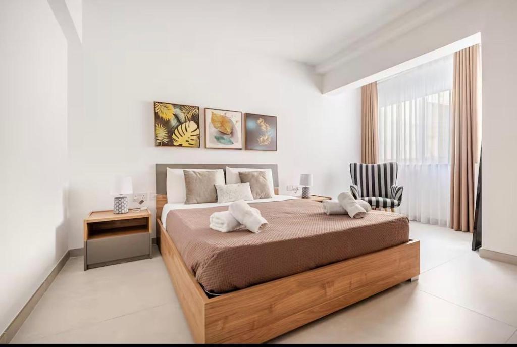 a bedroom with a bed and a desk and a window at Gzira Getaway in Il-Gżira