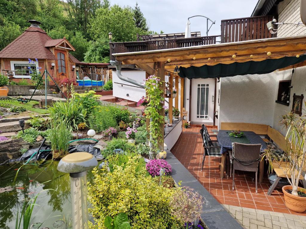 a garden with a table and chairs and a pond at Ferienwohnung Am Öpitzer Berg in Pößneck