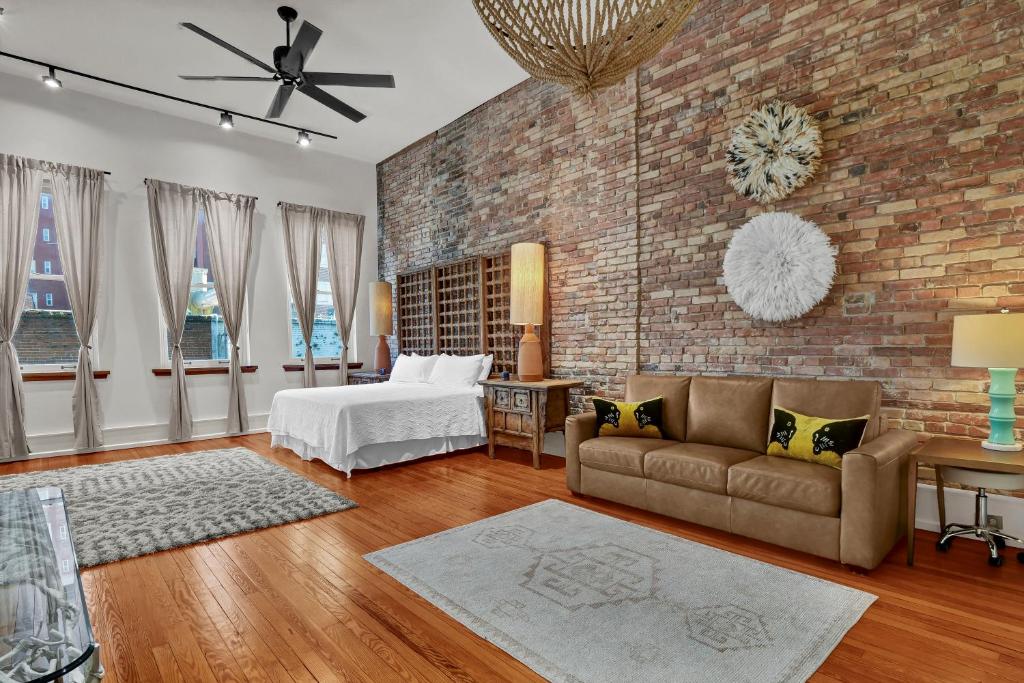 a bedroom with a bed and a brick wall at Luxe 220 Suite 4 in Wilmington