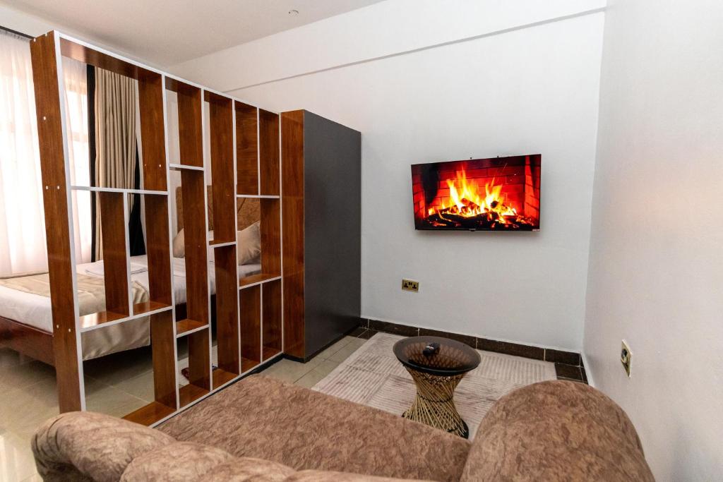 a living room with a fireplace on the wall at MIG Studios in Nakuru