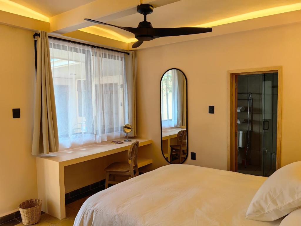 a bedroom with a bed and a desk and a window at The FLORENTHINA'S House in Oaxaca City