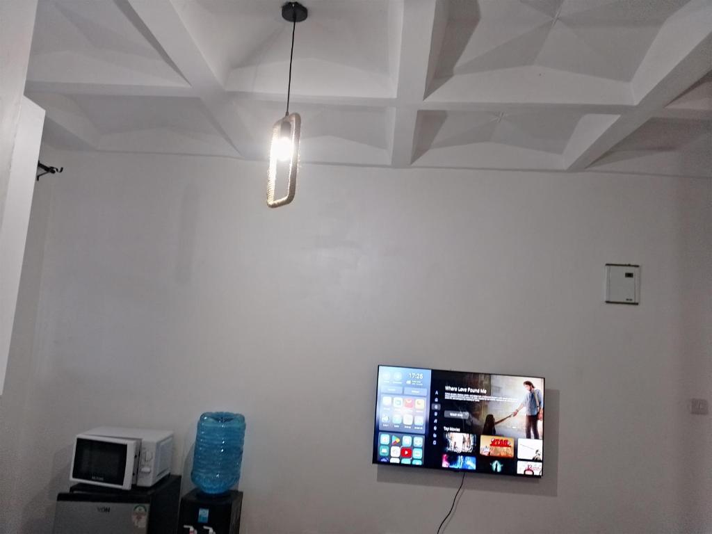 a flat screen tv hanging on a white wall at Magenche in Ongata Rongai 