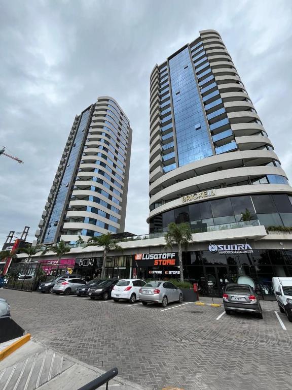 two tall buildings with cars parked in a parking lot at Brickell 3A in Tigre