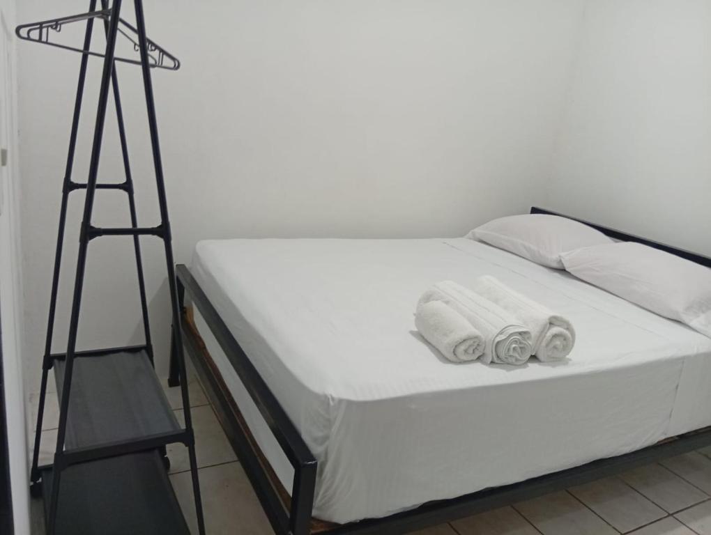 a bed with a ladder and two pairs of shoes on it at Apartamentos GoZu # 2 in Puerto Viejo