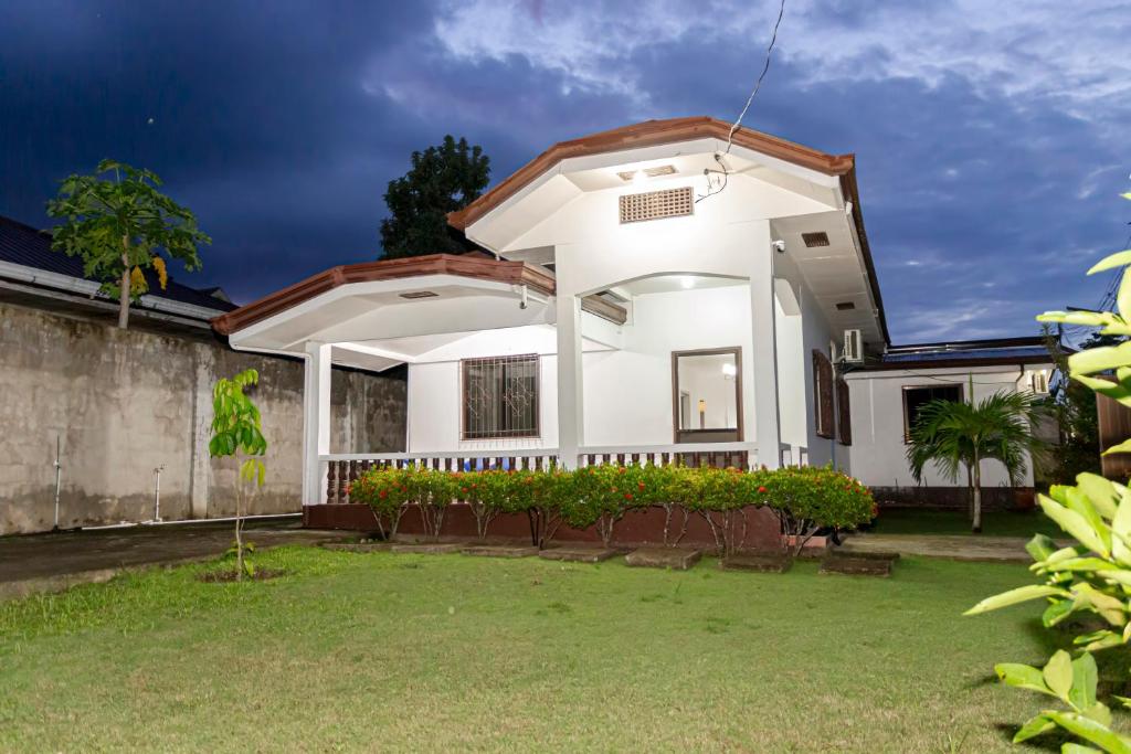 a white house with a large front yard at Casa Mutya in Dauis