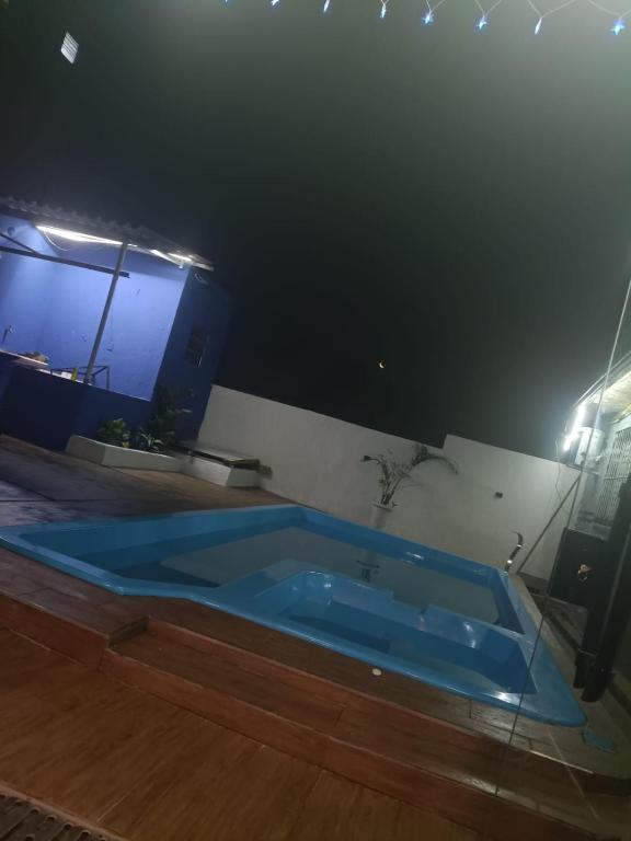 a blue tub in a room with a wooden floor at Espaço Bezerra in Itaquaquecetuba