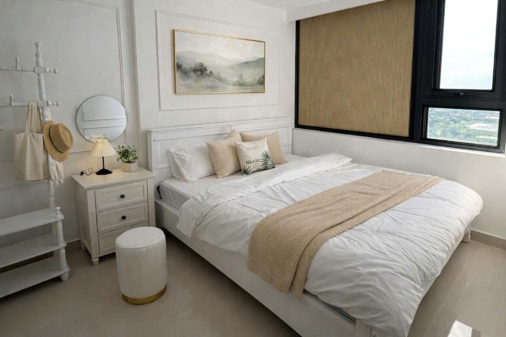 a white bedroom with a bed and a mirror at Hue Oi Homestay - Spacious 3-Bedroom Apartment with Balcony & Pool in Hue