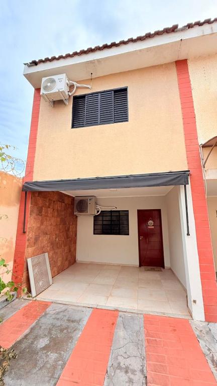 a building with a garage with a red door at Sobrado de luxo em condomínio in Araçatuba