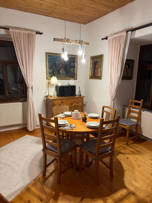 a dining room with a wooden table and chairs at Romantický vejminek pod horami in Kounov