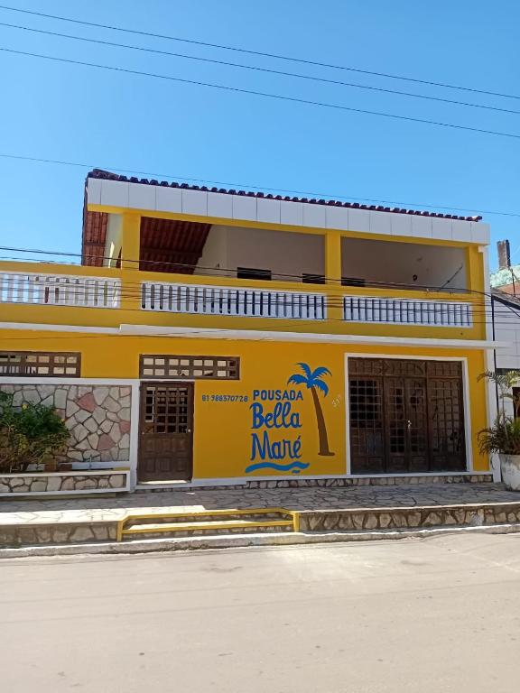 a yellow building with a sign on the side of it at Pousada Bella Maré in Goiana