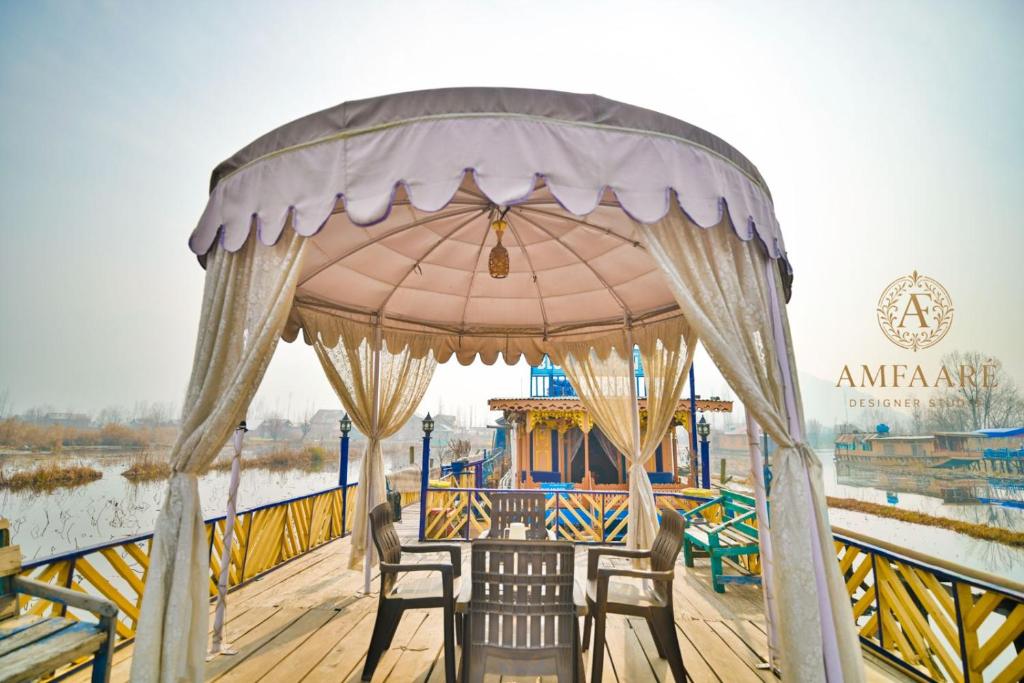 a gazebo with chairs and a table on a boat at Dolphin houseboat in Srinagar