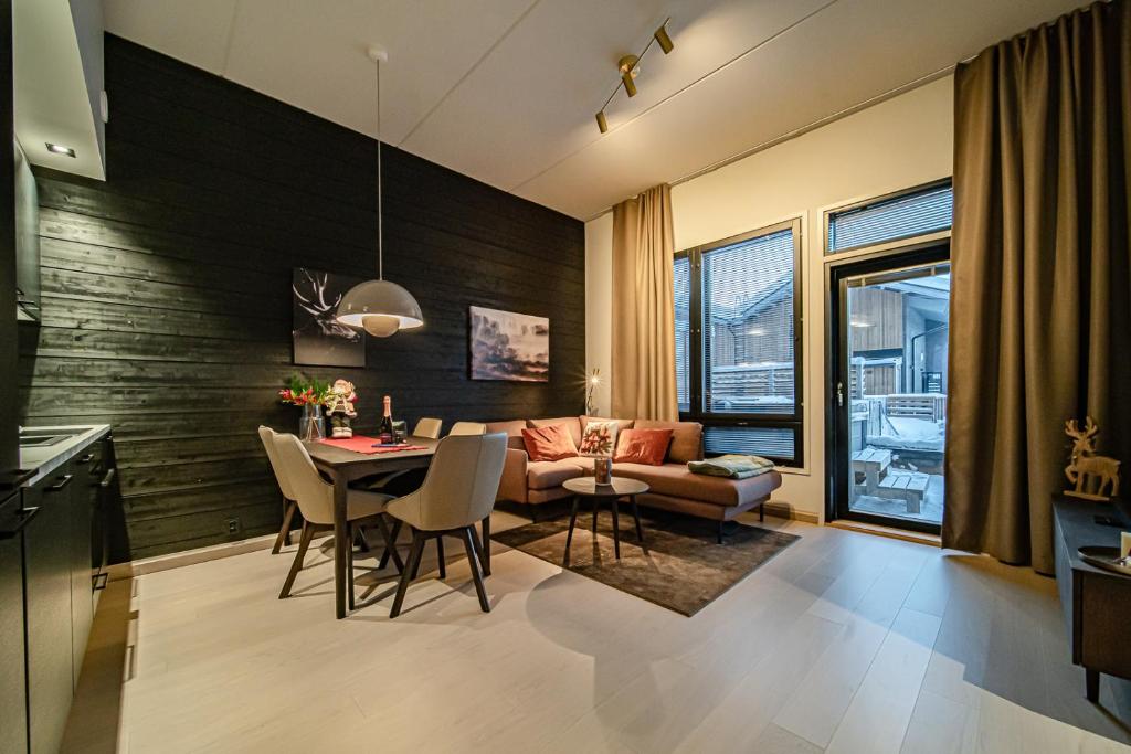 a living room with a table and a couch at Le Chalet Lingonberry D3 Ski-in Ski-out, Hot Tub by Aavalevi in Levi