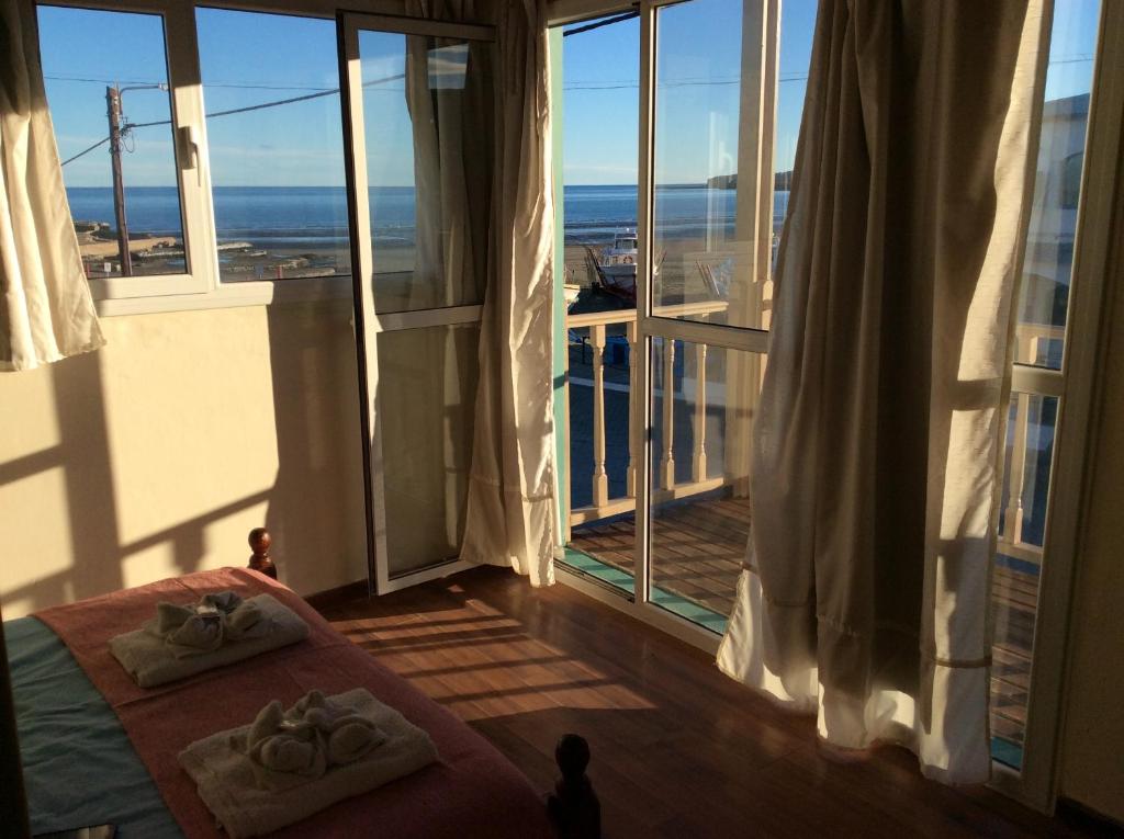 a bedroom with a bed and a balcony with a view at El Atardecer in Puerto Pirámides