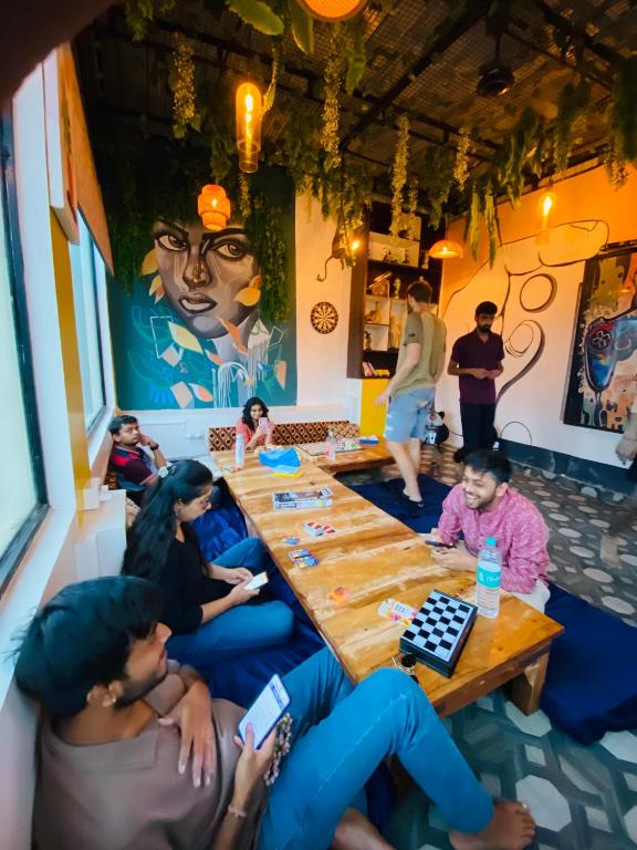 a group of people sitting around a table playing cards at The Commune Varanasi in Varanasi